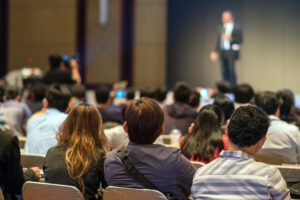 rear side of audiences sitting and listening the speackers on th